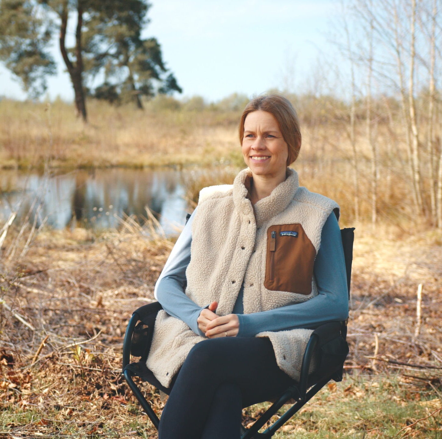 a woman sitting in a chair outside