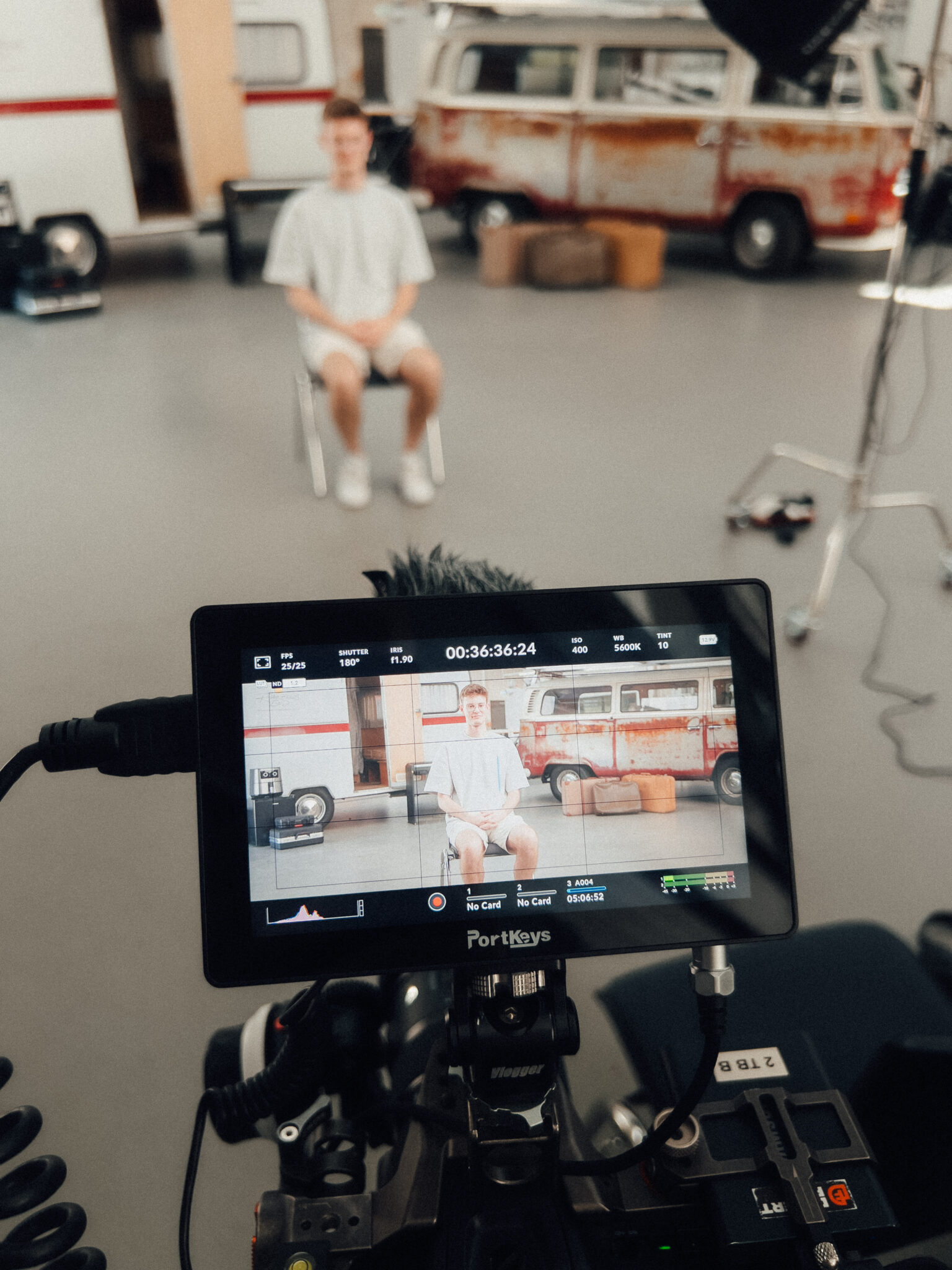 a camera screen with a man sitting in a chair