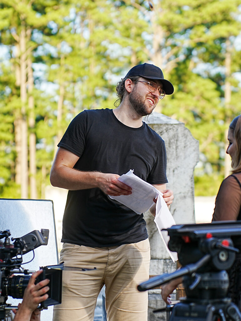 a man holding papers and a woman standing next to a camera