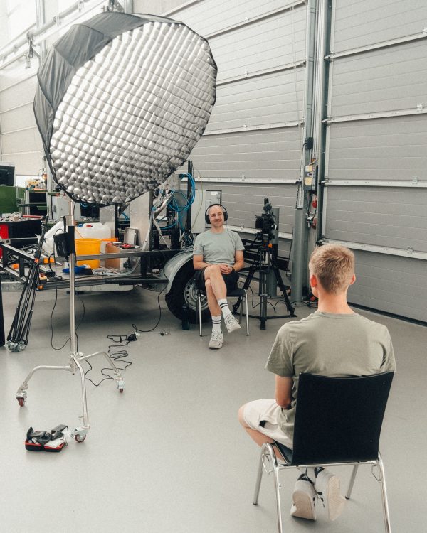 a man sitting in a chair in front of a camera