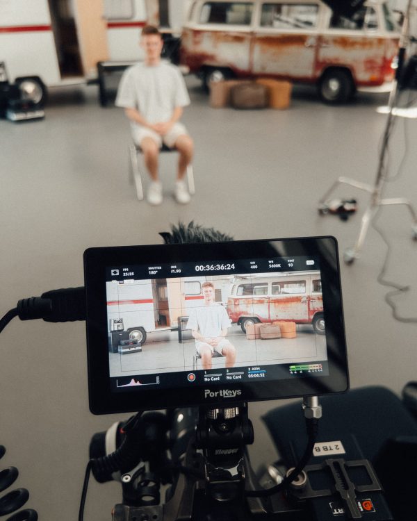 a camera screen with a man sitting in a chair