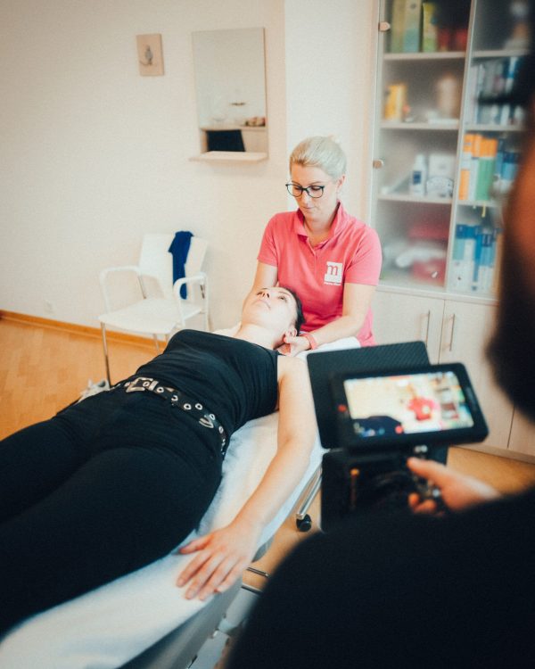 a camera man filming a physical therapist at work